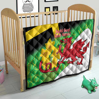 Welsh dragon St David's Day quilt over a crib mattress with green, yellow cross, red dragon.