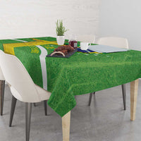 Green tablecloth on dining table with Brazil map, flag stripes, and Christ figure