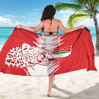 Red and white football sarong with leopard graphic and crest, held like a cape