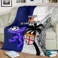 Rugby blanket showing THISTLE and FLYING FIJIANS text, blue mascot, white and black designs