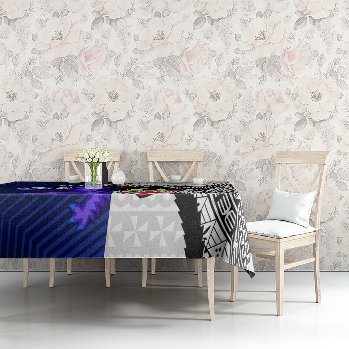 Rugby tablecloth on table with floral backdrop, blue panel and black-and-white tapa design
