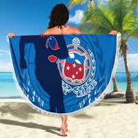 Blue circular beach blanket with fringe, Toa Samoa rugby crest graphic, held outdoors