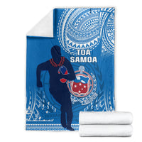 Folded blue rugby blanket with white Polynesian swirls, player silhouette, and league emblem