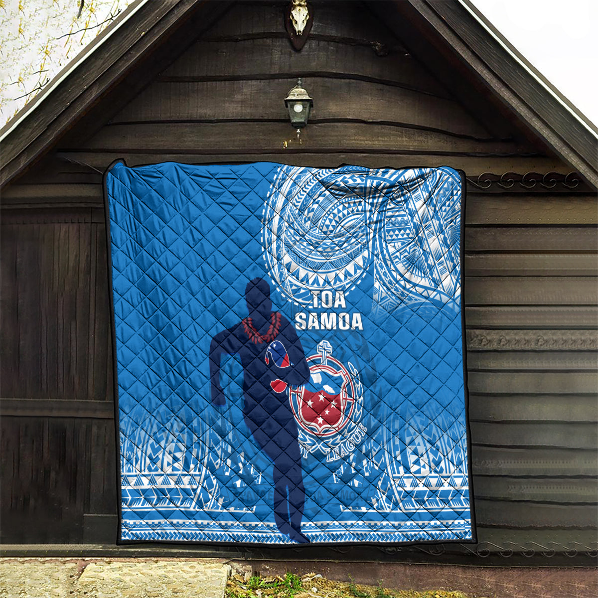 Blue quilted Samoa rugby blanket with white spiral design and dark player silhouette