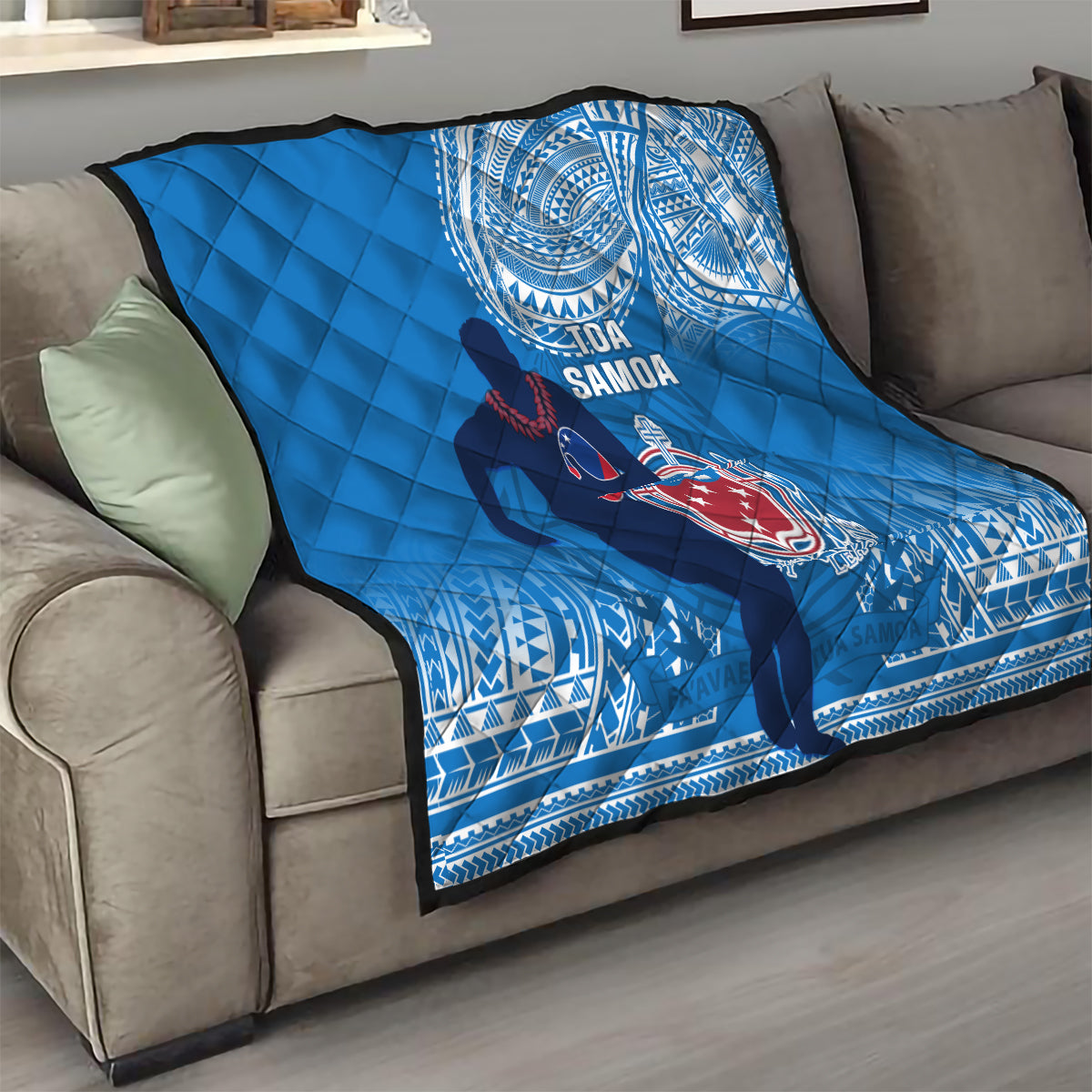 Blue Samoa rugby quilt on gray sofa with quilted diamond texture and emblem