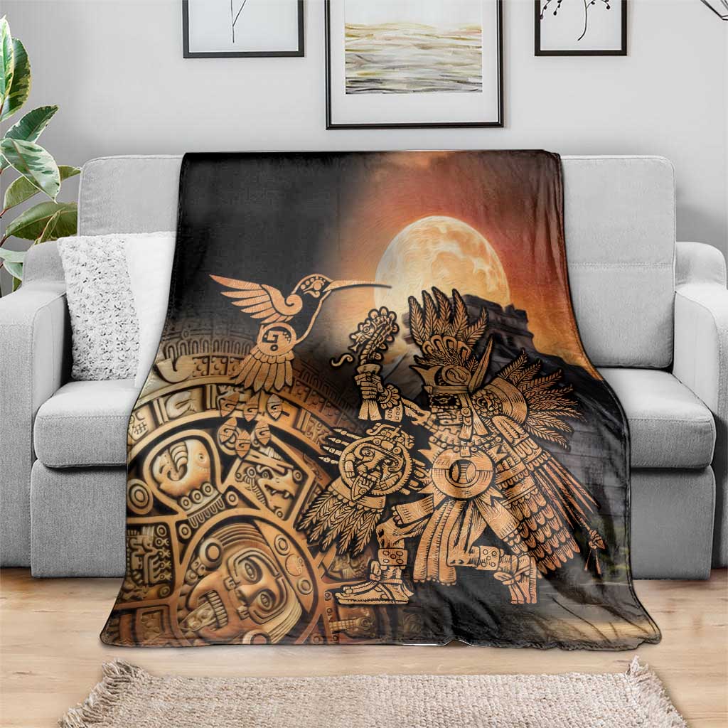 Black Aztec blanket with golden warrior and hummingbird centered, spread over light sofa