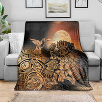 Black Aztec blanket with golden warrior and hummingbird centered, spread over light sofa