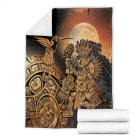 Black Aztec blanket with gold hummingbird and warrior, folded with white towels