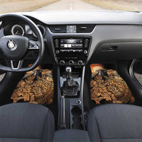 Black car floor mat pair with gold Aztec warrior and hummingbird artwork, dashboard view