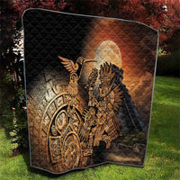 Black quilted blanket showing Aztec warrior and feathered bird figures with warm golden print
