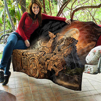 Black quilted blanket draped on couch with Aztec warrior and bird motif in golden tones