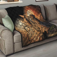 Black quilted throw blanket on sofa with Aztec warrior and feathered bird design in gold