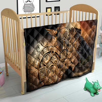 Black quilted baby blanket in crib with Aztec warrior feathered bird artwork in gold