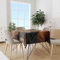 Aztec warrior tablecloth draped on dining table, black with golden hummingbird motifs