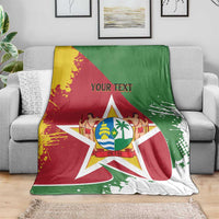 Suriname flag blanket coat with coat-of-arms star, red and green with yellow accents, on gray sofa