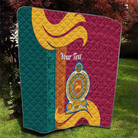 Square teal and maroon quilt with gold scroll design and circular crest emblem, quilted.