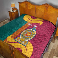 Teal and maroon quilt with gold and crest medallion over a bed, quilted.