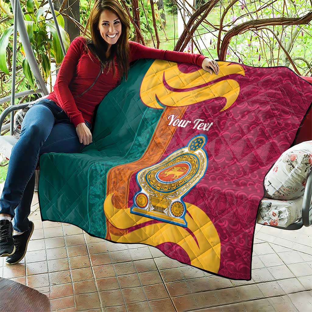 Teal and maroon quilt draped outdoors with gold crest emblem and swirling scroll, quilted.