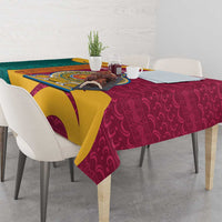 Maroon tablecloth with gold, teal, and yellow wave design and lion crest center.