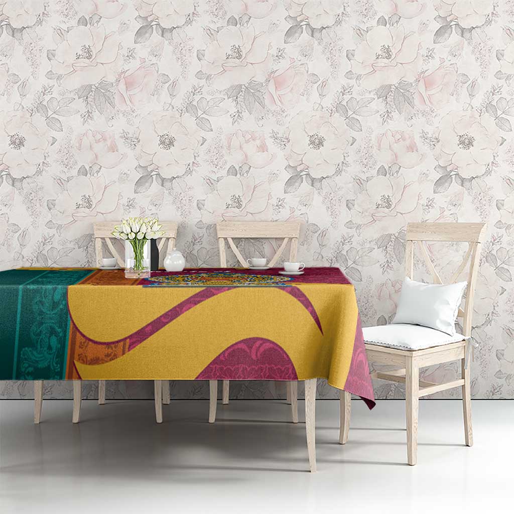 Maroon tablecloth with gold and teal ornate swirls, draped across dining table.