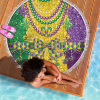 Round beach blanket with purple, green, and gold fleur-de-lis print and white fringe