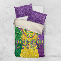 Mardi Gras bedding set shown flat: purple glitter pillowcases and fleur-de-lis patterned comforter