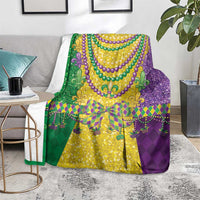 Mardi Gras throw blanket in purple, green, and gold with decorative fleur-de-lis motifs