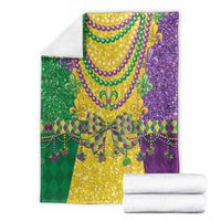Folded Mardi Gras blanket set with purple and green fleur-de-lis bead pattern