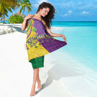 Fleur-de-lis sequin sarong draped over shoulders; purple top, green bottom, gold center