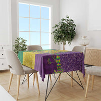 Mardi Gras tablecloth draped over dining table in purple and gold with green accents