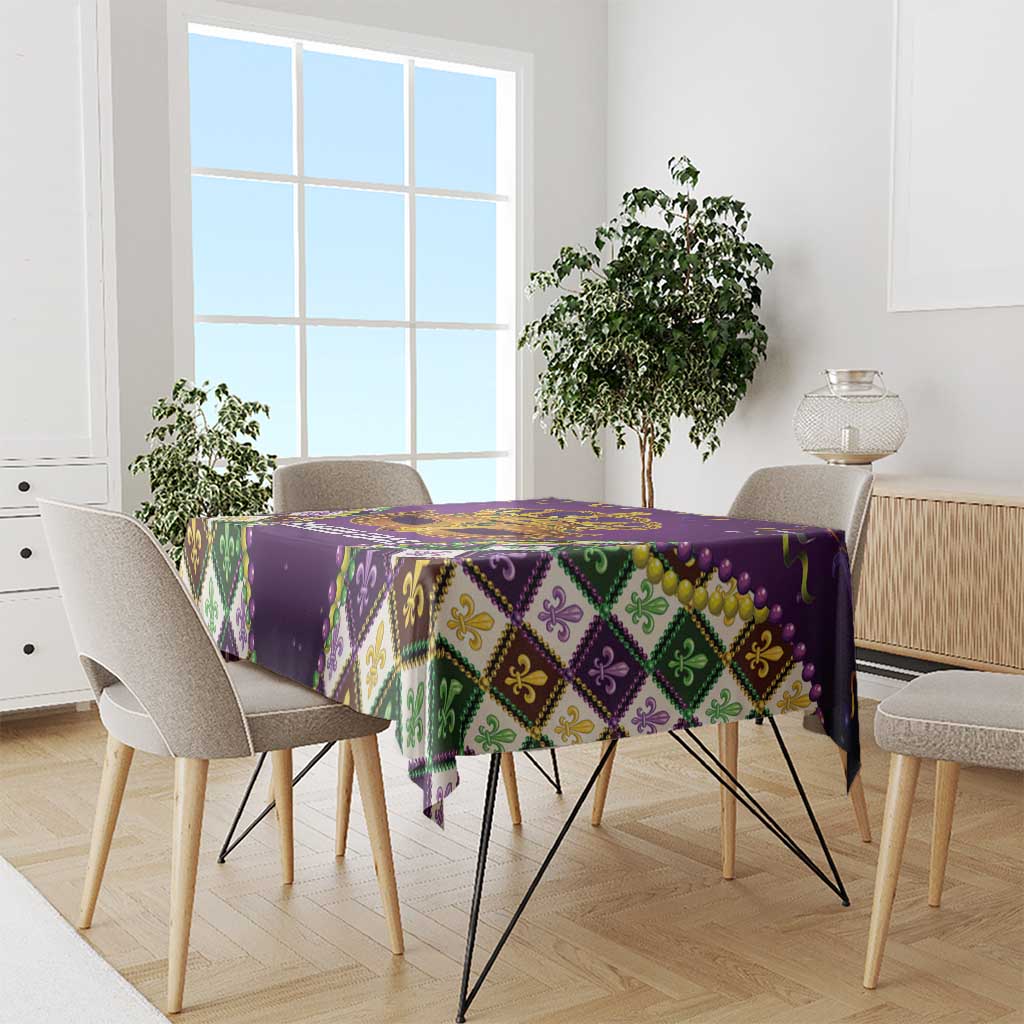 Purple tablecloth with multicolor diamond pattern and gold bead trim across tabletop