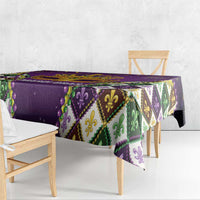 Purple tablecloth draped on dining bench, featuring colorful diamond design and gold trim