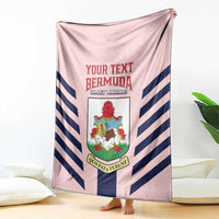 Pink throw blanket with navy-and-white chevron stripes and central shield crest logo