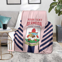 Pink blanket with navy-and-white diagonal stripes and colorful shield crest print