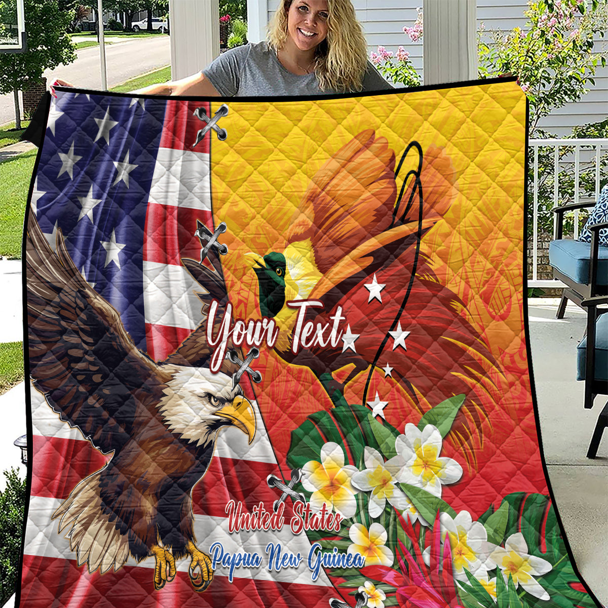 Personalized quilt held outdoors with US and PNG flags, eagle and tropical blossoms