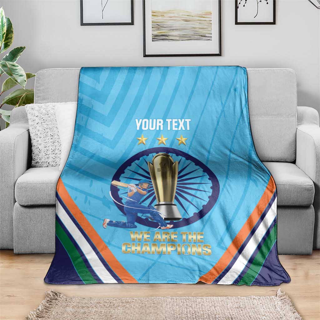 Blue cricket throw blanket draped on sofa, trophy emblem and 'We are the Champions'