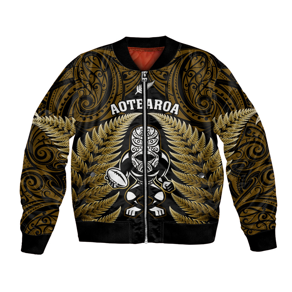 Gold bomber jacket with black zip front and tiki/fern tribal graphic