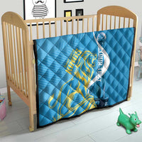 Blue quilt in baby play yard with Saint Lucia Kings gold lion and oval graphic