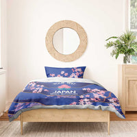 Blue bedding set with duvet and two pillowcases, cherry blossom design on bed