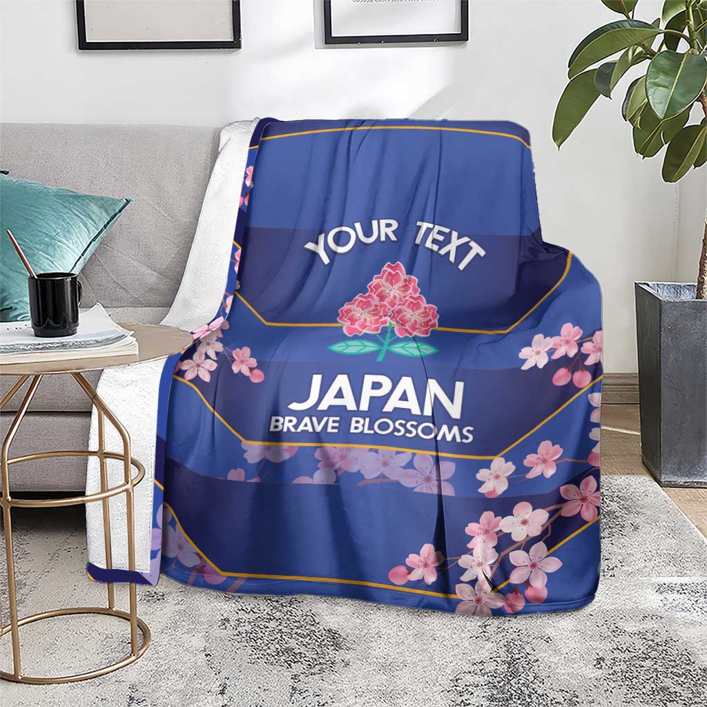 Blue rugby blanket on gray sofa with 'YOUR TEXT' and 'JAPAN BRAVE BLOSSOMS' art