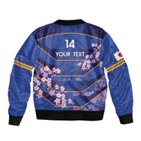Blue bomber jacket back with cherry blossom print, large '14' and 'YOUR TEXT', ribbed black hem