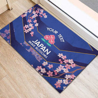 Blue rectangular rubber doormat with cherry blossom border and 'YOUR TEXT' over JAPAN BRAVE BLOSSOMS.