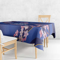 Blue tablecloth with pink blossom print and gold border, draped over a table