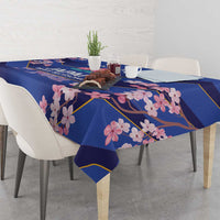 Blue tablecloth with pink blossoms and gold trim, covering a dining table