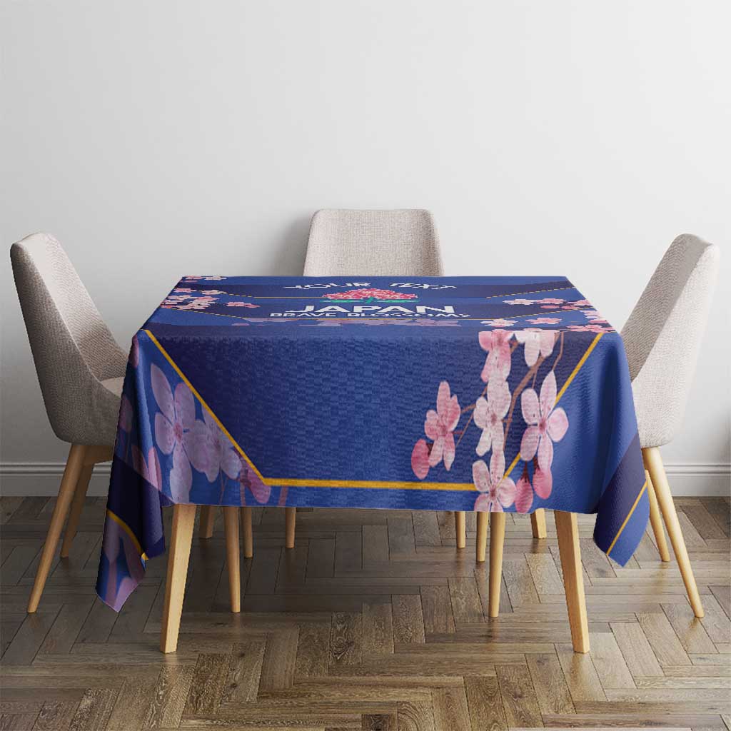 Blue tablecloth with pink blossom print and gold edging, on a dining table
