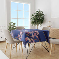 Blue tablecloth with pink blossoms and gold border, on a dining table with chairs