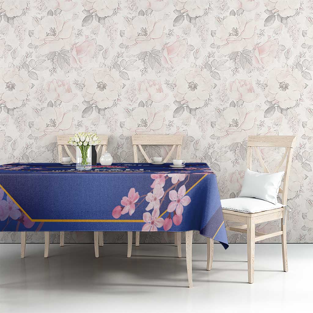 Blue tablecloth with pink blossom print and gold border, on a dining table