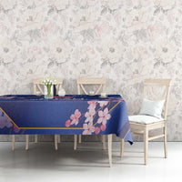 Blue tablecloth with pink blossom print and gold border, on a dining table