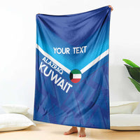 Blue custom football blanket with 'YOUR TEXT' and Kuwait motif, upright on display