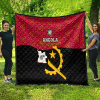 Angola quilt stretched outdoors, red geometric upper and black quilted bottom with yellow emblem